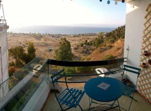a balcony with a blue table and chairs and the ocean at Lovely apartment close to everything with a view! in Viña del Mar