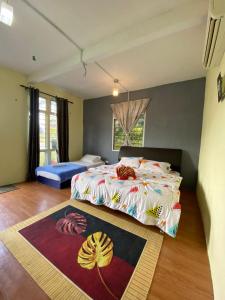 a bedroom with a bed and a rug on the floor at Kurau Stone Chalet in Taiping