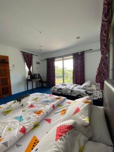 1 dormitorio con 2 camas con almohadas en Kurau Stone Chalet, en Taiping