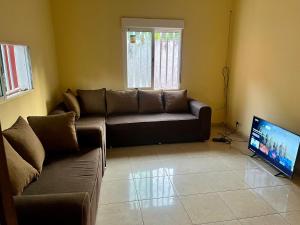 uma sala de estar com um sofá e uma televisão de ecrã plano em Appartement meublé Kolda em Kolda