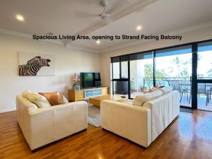 a living room with two couches and a tv at Townsville Lighthouse - 3/103 Strand in Townsville