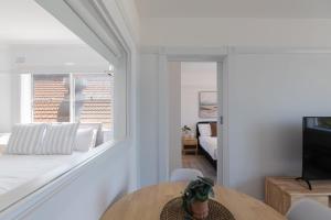 een woonkamer met een bank, een tafel en een televisie bij Bondi Beachfront Bliss in Sydney
