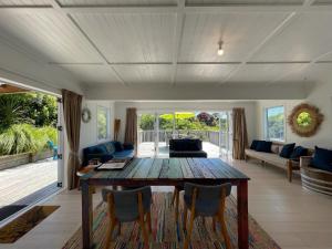a living room with a wooden table and chairs at Oneroa Village Oasis - Waiheke Escapes in Blackpool