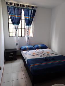 a bedroom with a bed and a window with curtains at Apartamento en Villavicencio in Villavicencio