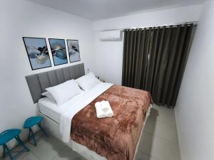 a bed in a room with two chairs and a bed sidx sidx sidx at Anfitrião Guiah! - Desperte os sentidos a beira-mar e ao lado do Centro de Convenções in Salvador