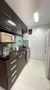 uma cozinha com um lavatório e um micro-ondas em Apartamento Maceió- Jatiúca em Maceió