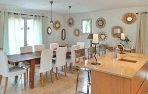uma sala de jantar com mesa, cadeiras e espelhos em Cozy Home In Paradou Centre With Heated Swimming Pool em Paradou