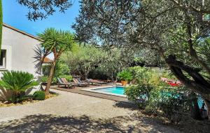 uma piscina num quintal com cadeiras e árvores em Cozy Home In Paradou Centre With Heated Swimming Pool em Paradou