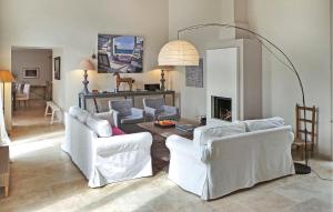 uma sala de estar com duas cadeiras brancas e uma mesa em Cozy Home In Paradou Centre With Heated Swimming Pool em Paradou