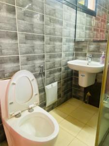 a bathroom with a toilet and a sink at Résidence El Hadji Annexe in Dakar