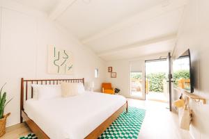 ein weißes Schlafzimmer mit einem Bett und einem Fenster in der Unterkunft The Green Room Hotel in Oceanside