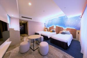 a hotel room with two beds and a table at Hotel Keihan Universal Tower in Osaka