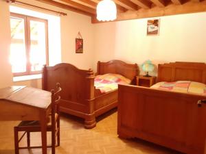 a bedroom with two beds and a table and a window at Gîte Sauvain, 4 pièces, 6 personnes - FR-1-496-94 in Sauvain