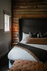 a bedroom with a large bed with a wooden wall at Cardrona Hotel in Cardrona