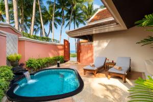 a backyard pool with a hot tub and two chairs at Santiburi Koh Samui in Mae Nam