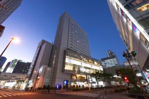 un grand bâtiment dans une ville la nuit dans l'établissement remm Akihabara, à Tokyo