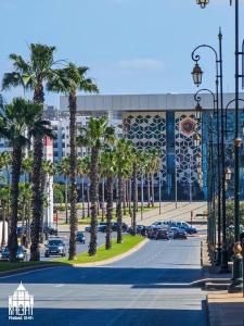 a street with palm trees in front of a building at Rabat, Hassan Downtown: Tramway, sunshine, privacy in Rabat