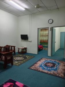una habitación con dos alfombras y un reloj en la pared en Nawlaa Homestay en Melaka