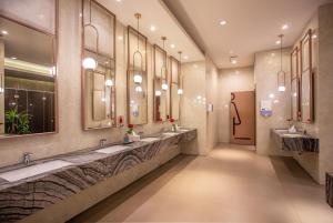 a large bathroom with two sinks and mirrors at HARRIS Hotel & Conventions Gubeng in Surabaya