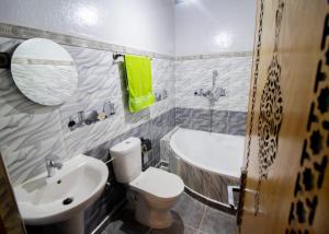 y baño con aseo, lavabo y bañera. en Palma Ziz, en Aït Athmane