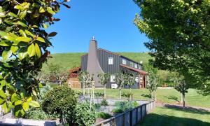 uma casa numa colina com uma cerca e árvores em Country Lodge Kinloch em Taupo