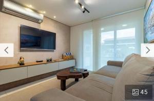 un soggiorno con divano e TV di Condomínio meridional a Tamandaré