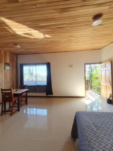 a bedroom with a bed and a table and a window at El Chagüite monteverde #2 in Monteverde Costa Rica