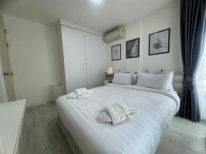 @ style sukhumwit bangna3 في بانغنا: غرفة نوم بسرير ابيض كبير عليها مناشف