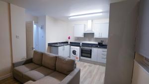 a living room with a couch and a kitchen at Luxury 2 Bed Apartment London Twickenham in Hounslow