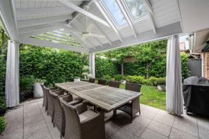 a patio with a wooden table and chairs at Iris at Norwood - Luxe Indoor-Outdoor Living near CBD in Norwood