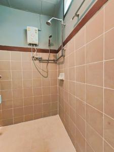 a shower in a bathroom with brown tiles at Panda House Chiang Mai in Chiang Mai