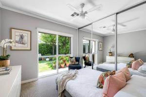 a bedroom with a bed and a large window at Iris @ Norwood - Luxe 4BR in Norwood
