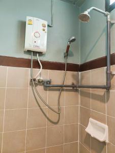 a shower in a bathroom with a toilet and a shower head at Panda House Chiang Mai in Chiang Mai