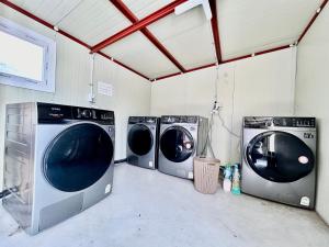 drei Waschmaschinen in einer Waschküche in der Unterkunft Royal motel in Goseong
