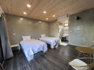 1 dormitorio con 2 camas, mesa y sillas en Hey Castle B&B, en Xiaoliuqiu