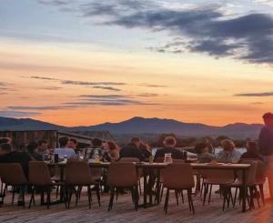 a group of people sitting at a table at sunset at Yeruu lodge in Jargalant