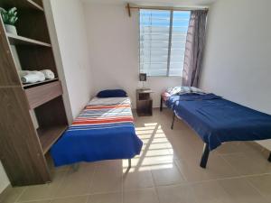 Duas camas num quarto com uma janela em Casa amplia Garde SD em Querétaro