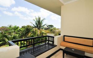 a balcony with a bench and a view of palm trees at Blue Point Resort and Spa in Uluwatu