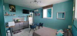 una camera blu con letto e cucina di Ti' cocon des îles a Le Moule