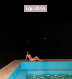 a woman laying on the edge of a swimming pool at Irakara hotel campestre in La Palma