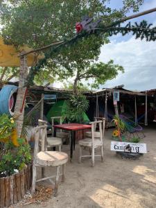 a table and chairs in front of a tent at Casa de los Santos Camping y eco cabañas in Holbox Island