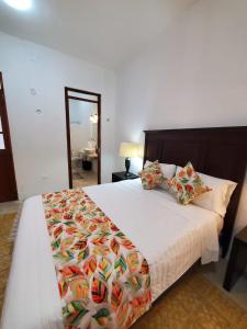 a bedroom with a large bed with a comforter and pillows at Habitación Fuoco in Mérida