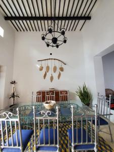 a dining room with a glass table and a chandelier at Habitación Fuoco in Mérida