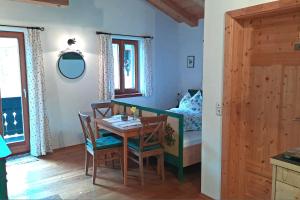 a dining room with a table and chairs and a bed at Bauernhof Auerhof Ferienwohnung in Aschau im Chiemgau