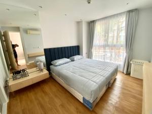 sypialnia z dużym łóżkiem i dużym oknem w obiekcie Grand Caribbean Condo Resort Pattaya 19 floor w Pattaya South