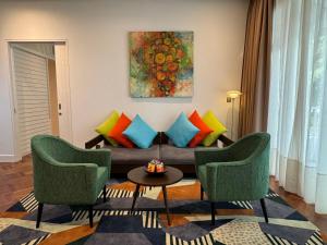 a living room with a couch and two chairs at Lone Pine, Penang, a Tribute Portfolio Resort in Batu Ferringhi