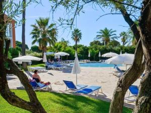 einen Strand mit Stühlen und Sonnenschirmen sowie einen Pool in der Unterkunft T2 avec Piscine, Vue Mer, Parking, à 200m de la Plage - FR-1-768-70 in La Garonnette-Plage