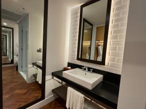 a bathroom with a sink and a mirror at Lone Pine, Penang, a Tribute Portfolio Resort in Batu Ferringhi