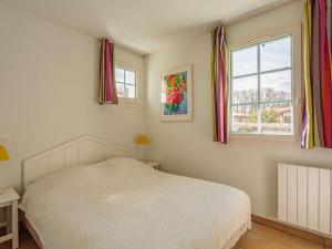 a bedroom with a white bed and a window at Grand appartement familial avec piscine près de Saint-Jean-de-Luz - FR-1-2-439 in Urrugne