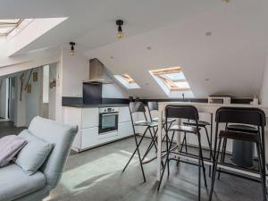 a living room with a couch and some bar stools at Appartement Rénové Quartier des Halles Biarritz - FR-1-3-604 in Biarritz